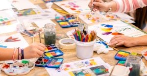 教育現場で、子供たちが絵の具や色鉛筆を使って自由に絵を描いている様子。組み立て式の教材や色彩豊かな画材が、自立と集中を促し、想像性を刺激している。